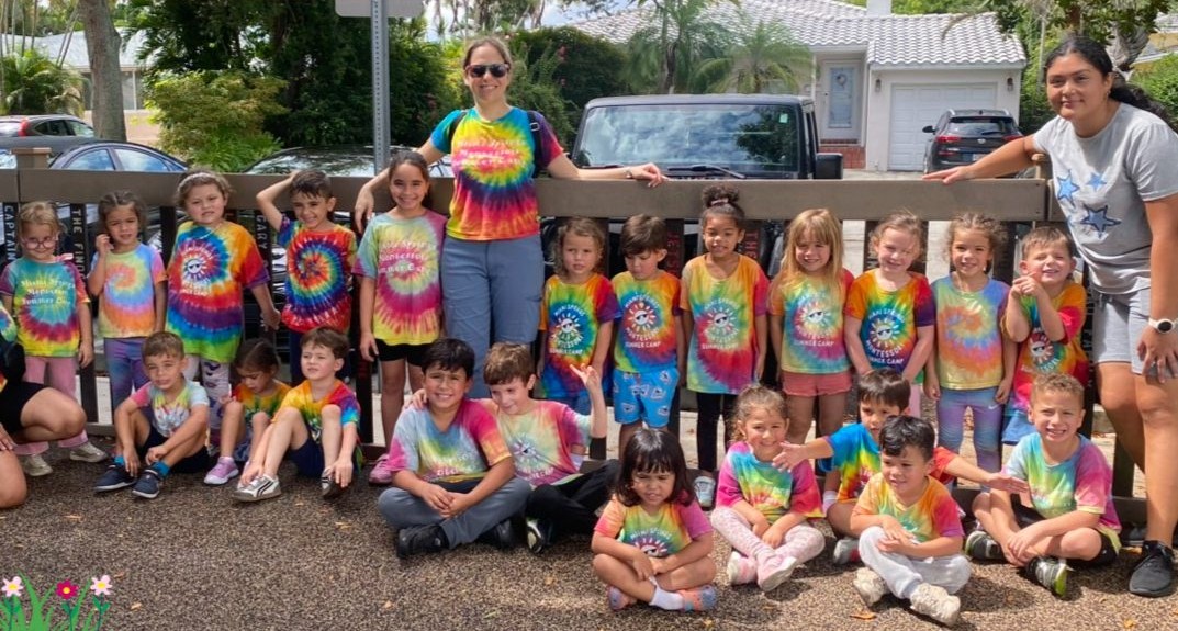 Group of children in tie-dye shirts on a nature walk to the park
